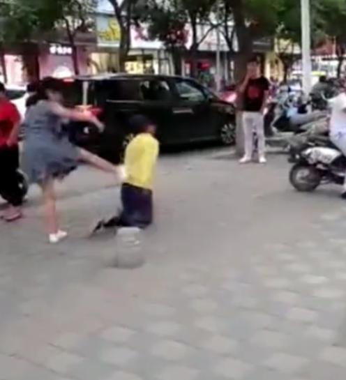  男子被女子当街训斥跪地学狗爬,之后猛踹男子背部引发路人围观