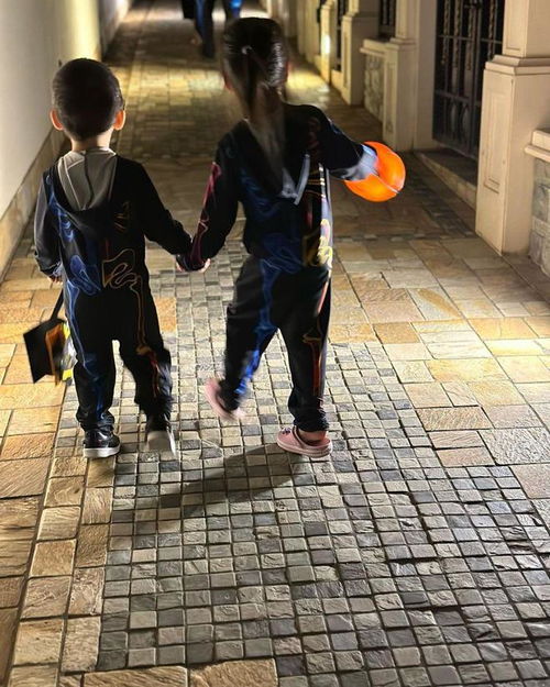 杨怡罗仲谦与子女穿亲子装参加活动一对子女手牵手走路很温馨